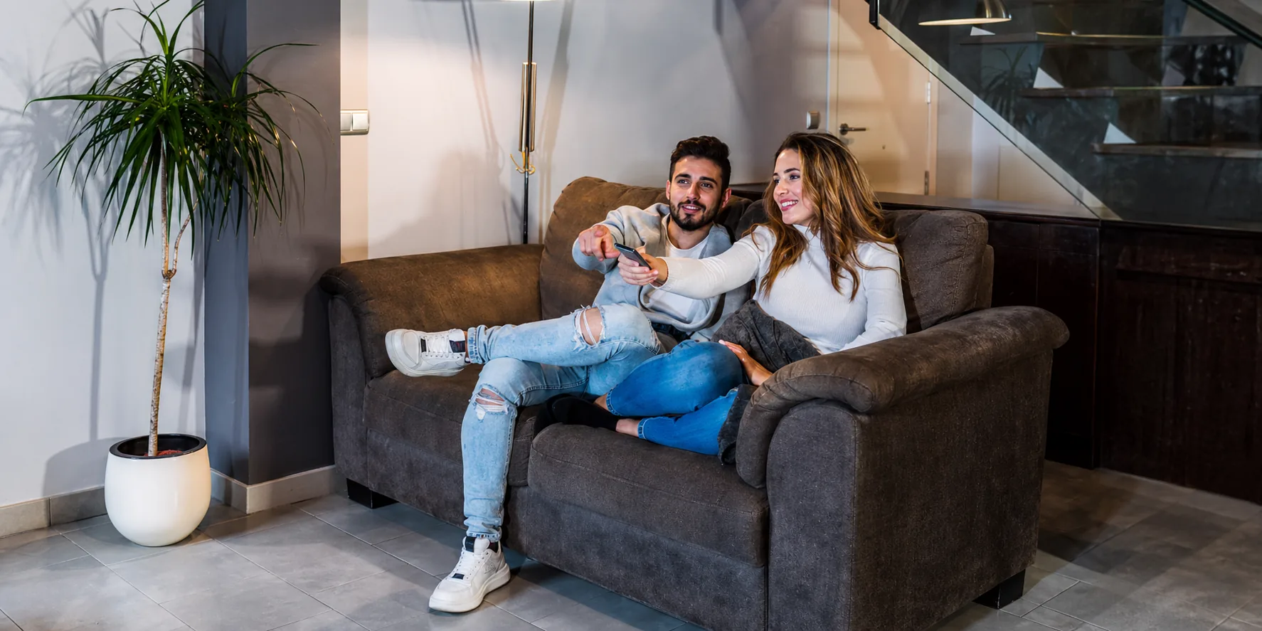Pareja disfrutando en el sillón de su nuevo alquiler